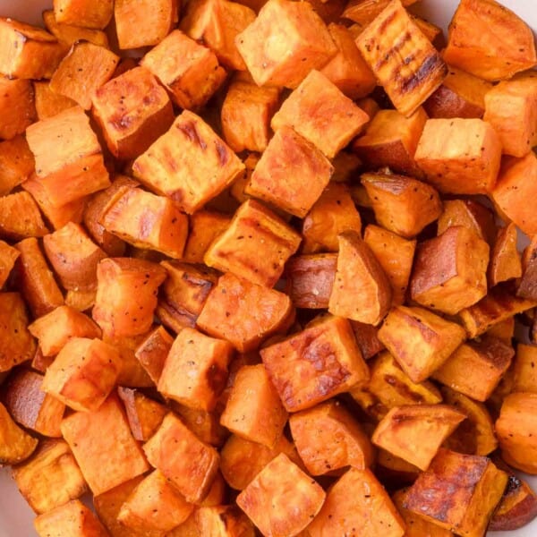 Close-up of roasted sweet potato cubes with a slightly crispy, browned exterior.