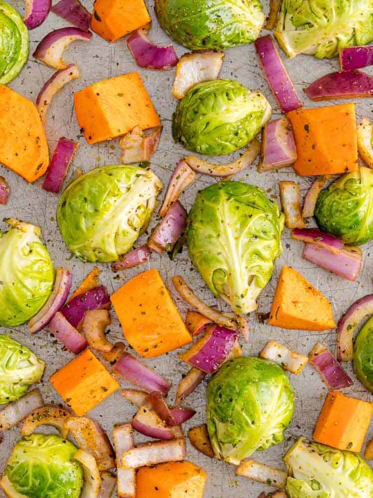 Uncooked vegetables arranged on a sheet pan.