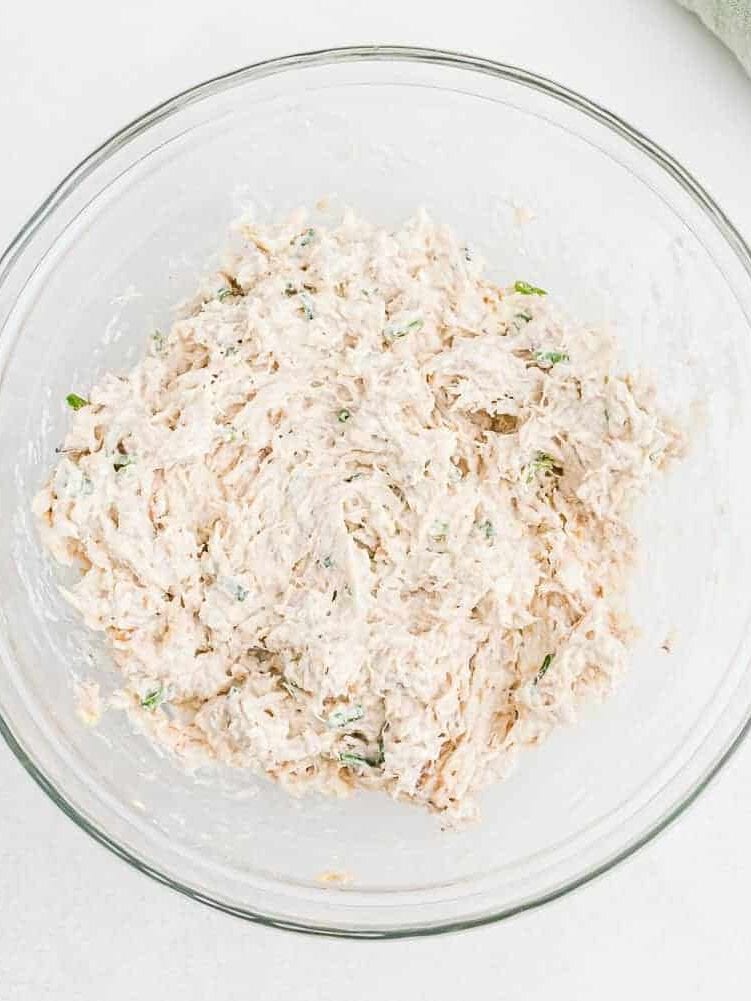 Crab filling in a clear glass mixing bowl.