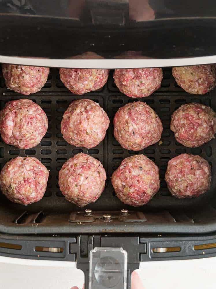 Uncooked meatballs in the air fryer.