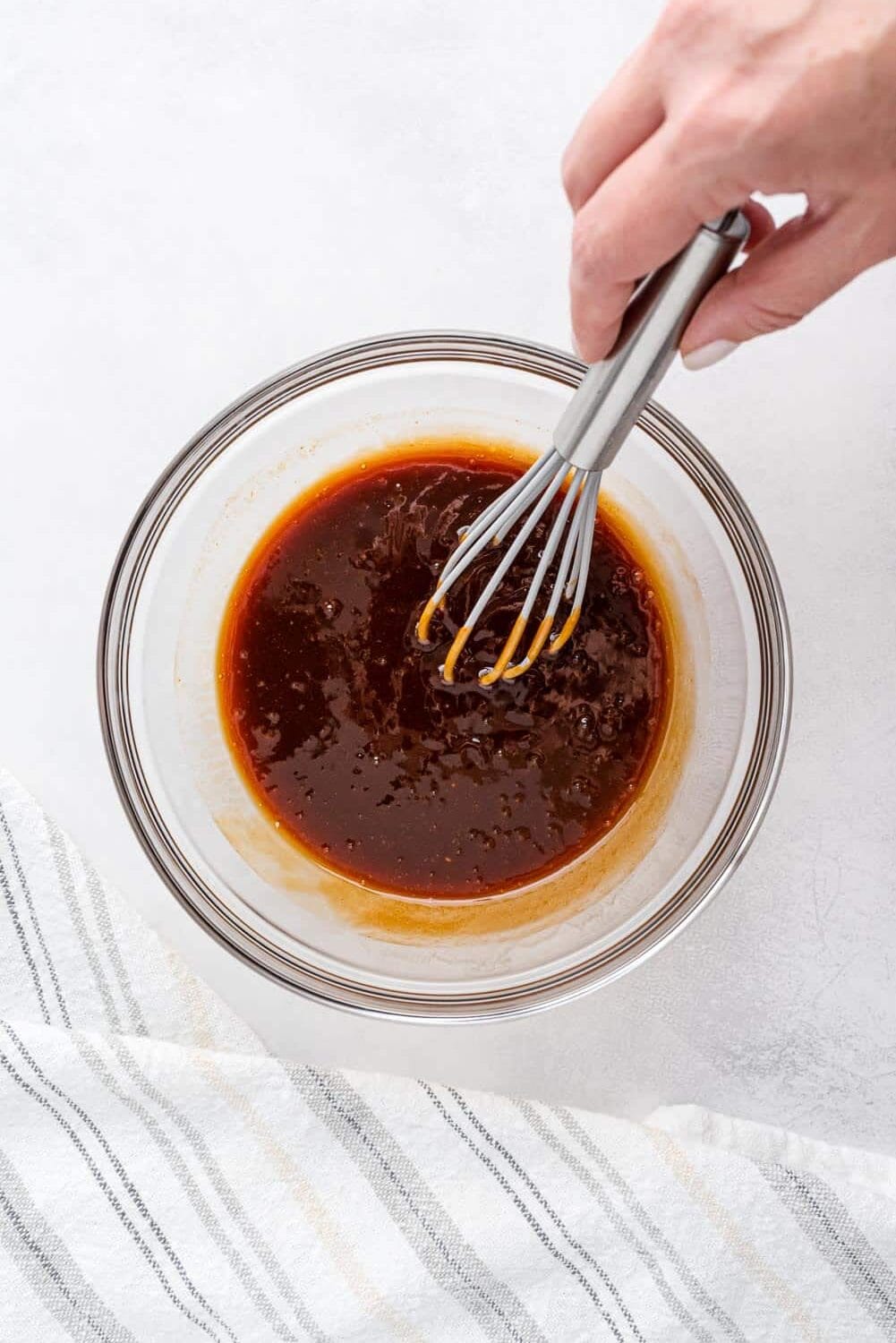 Sauce being whisked together in a small glass bowl.