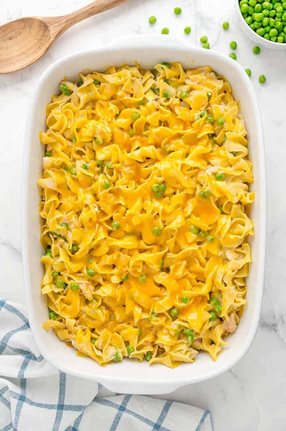 Baked casserole with tuna and peas in a white baking dish.