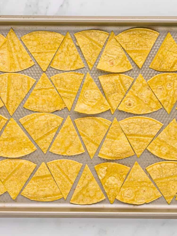 Unbaked tortilla wedges on a baking sheet.