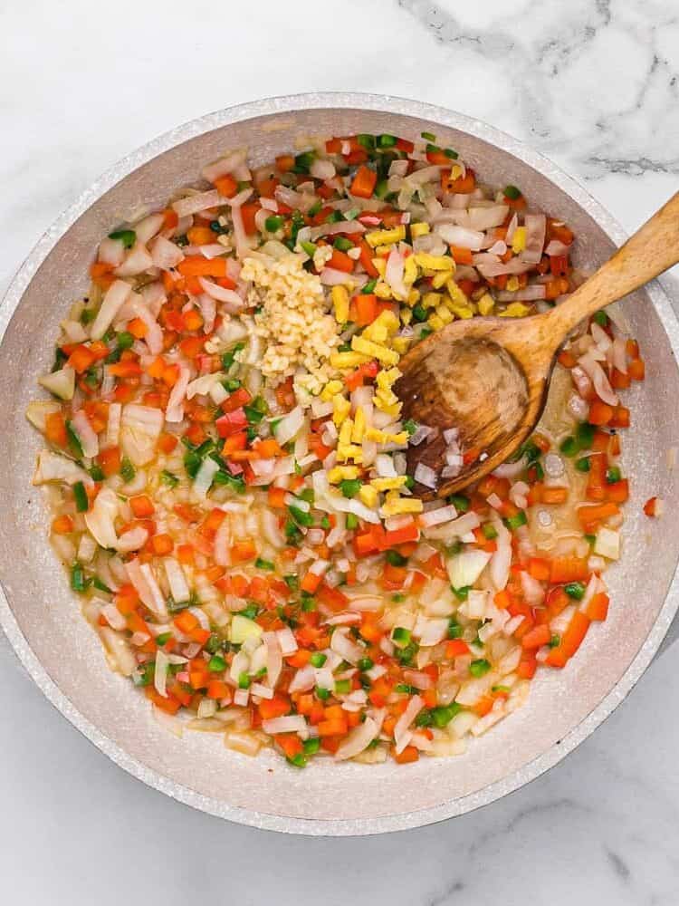 Peppers, onions, garlic, ginger in pan.