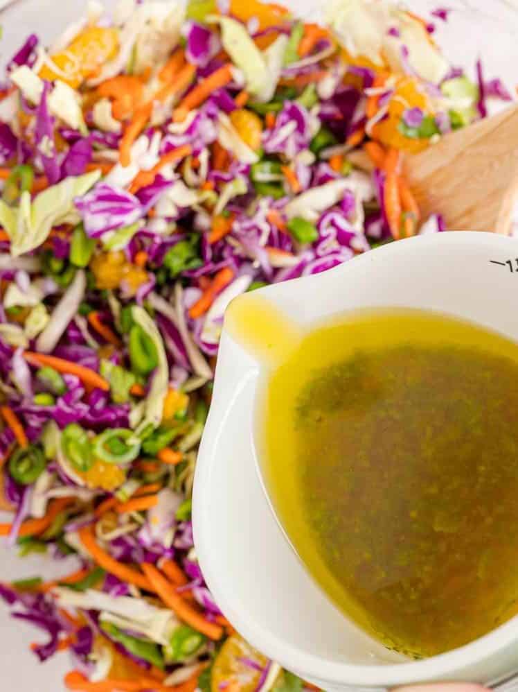 Dressing being poured onto salad.