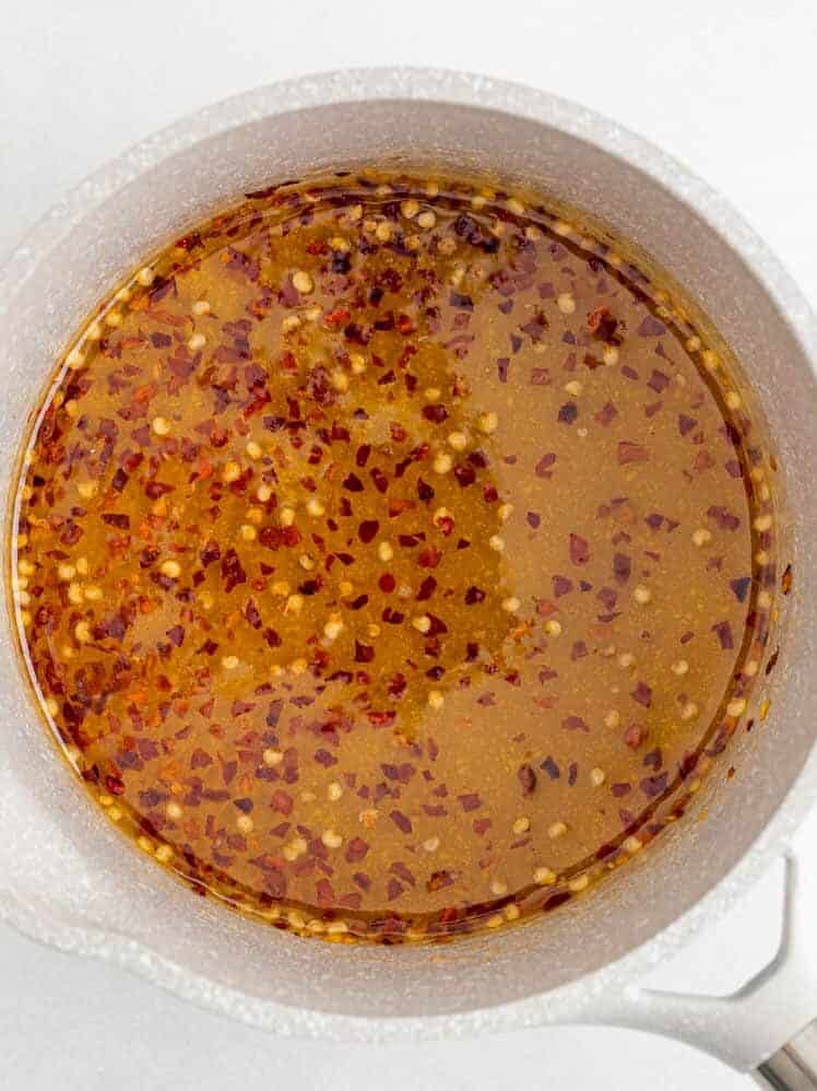 Honey with red pepper flakes in a saucepan.