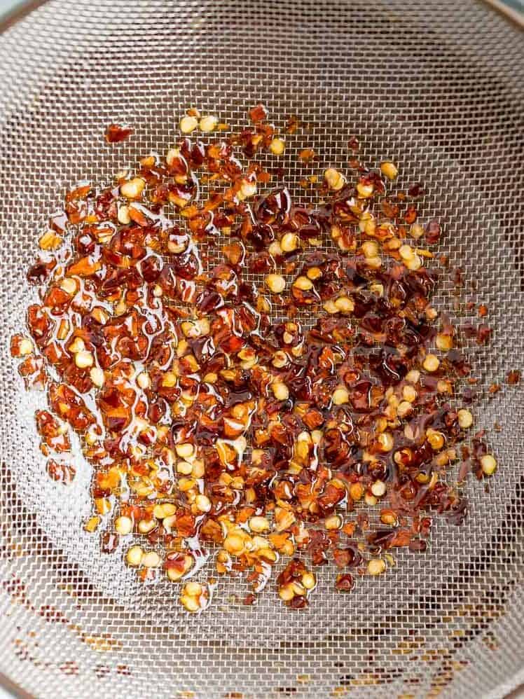 Red pepper flakes in a strainer.