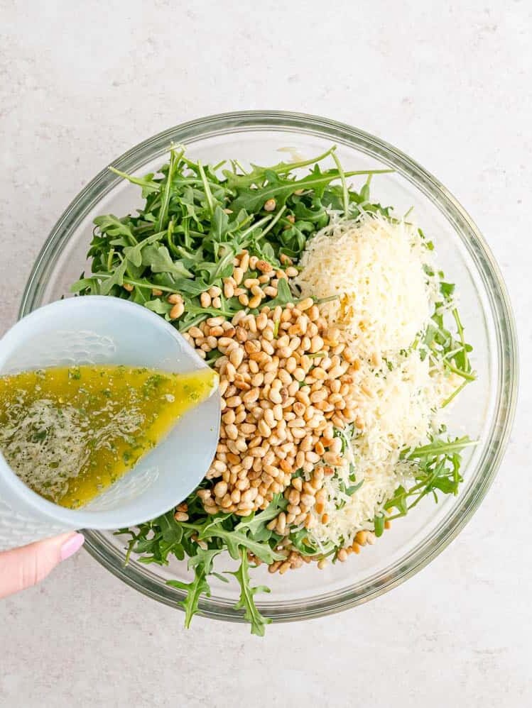 Dressing being added to salad.