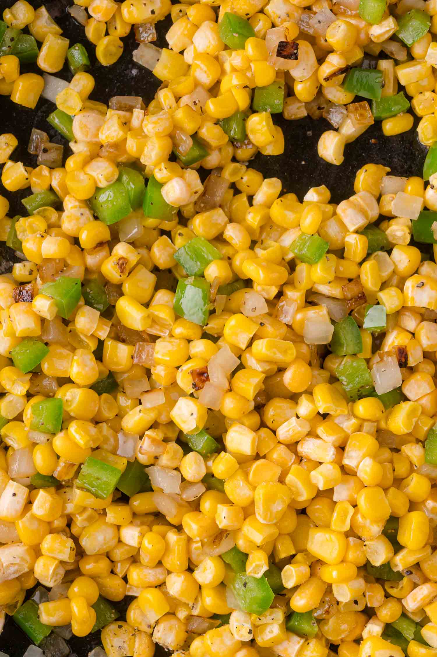 Close-up of sautéed corn mixed with chopped jalapeno and onions.