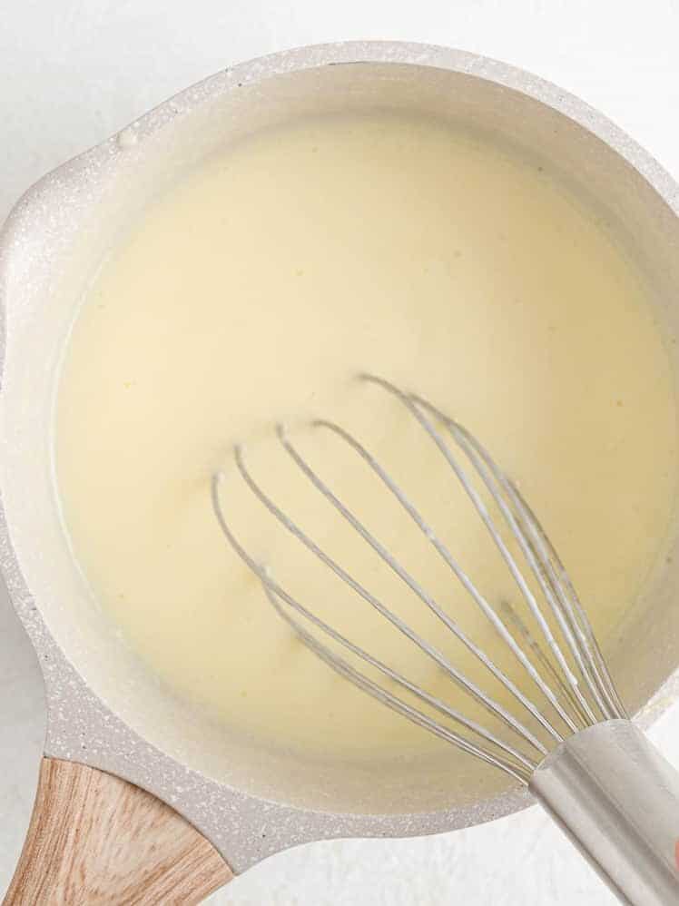 Milk being whisked in.
