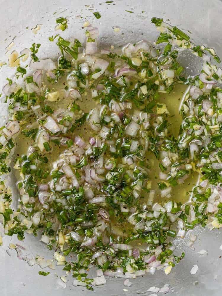 Chopped shallots, garlic, and fresh herbs mixed with oil and vinegar.