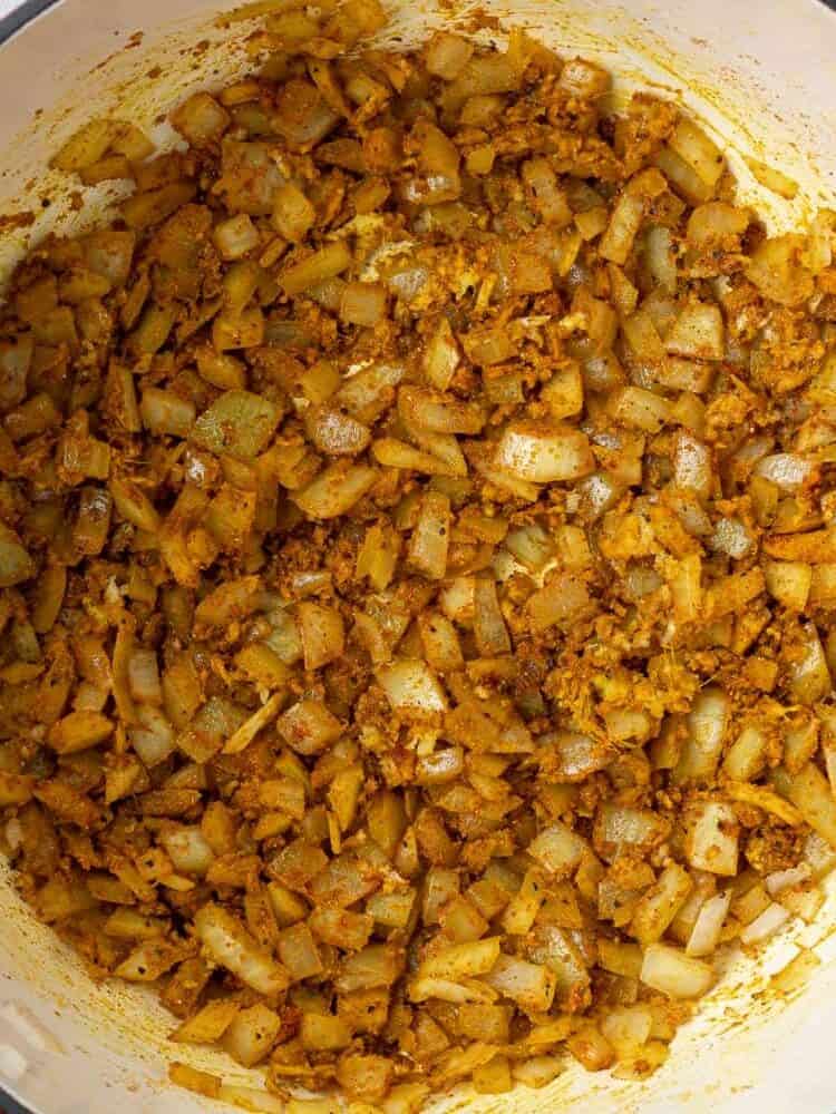 Vegetables sautéed in a large red dutch oven.