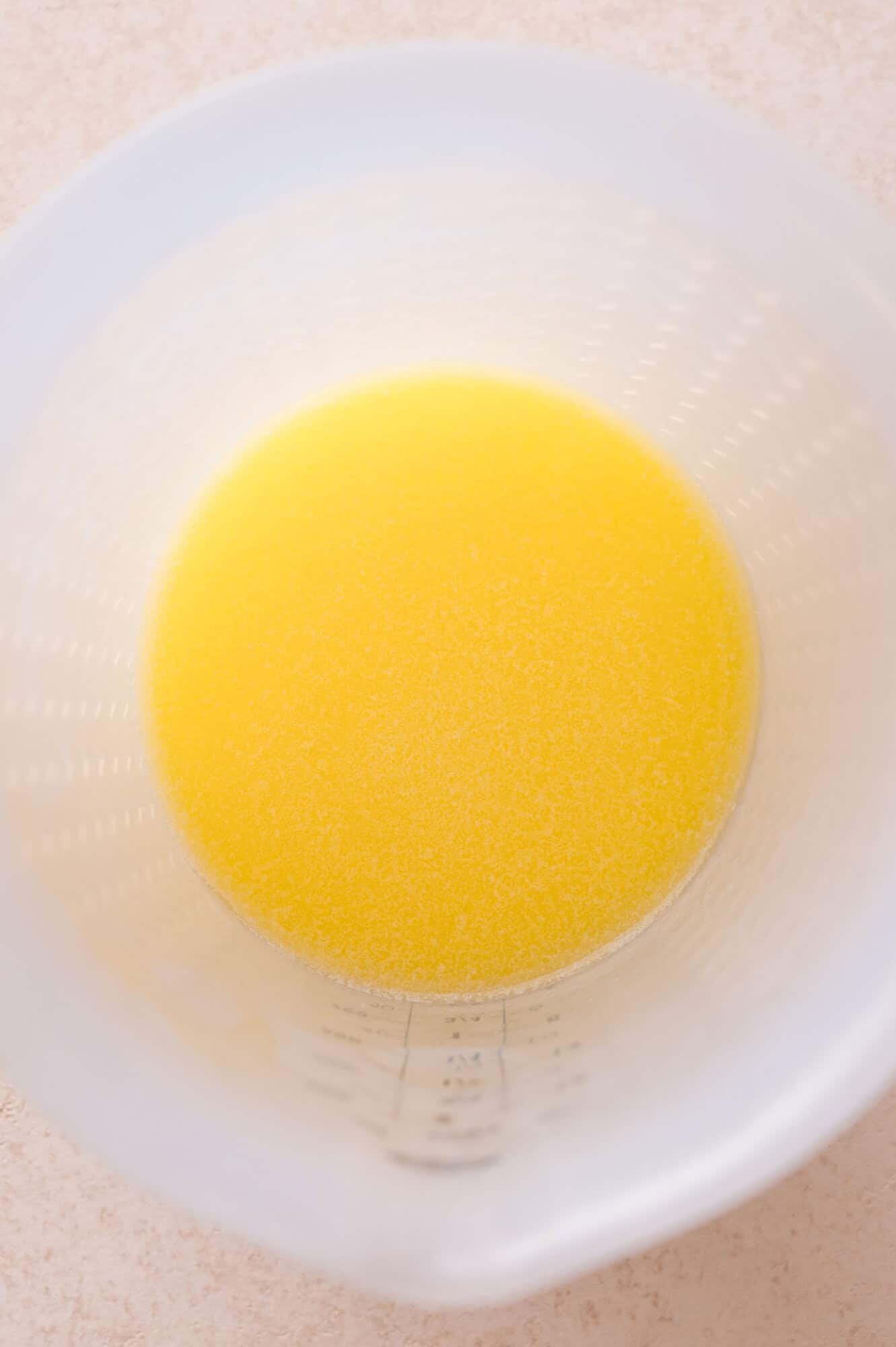 A top-down view of melted butter in a measuring cup.