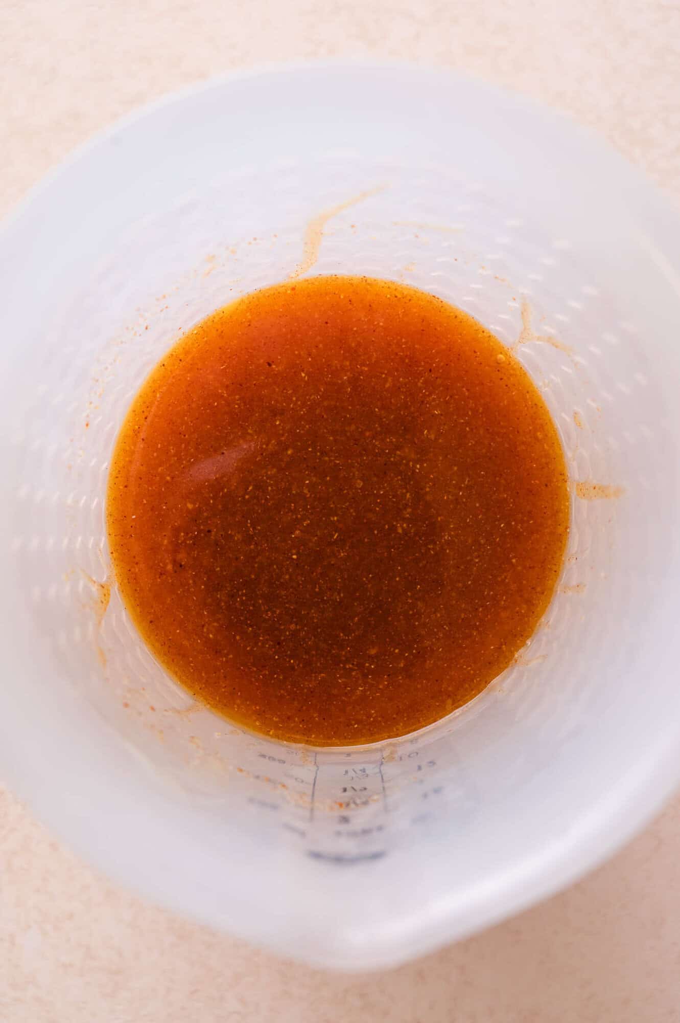 Melted butter and spices in a translucent measuring cup.