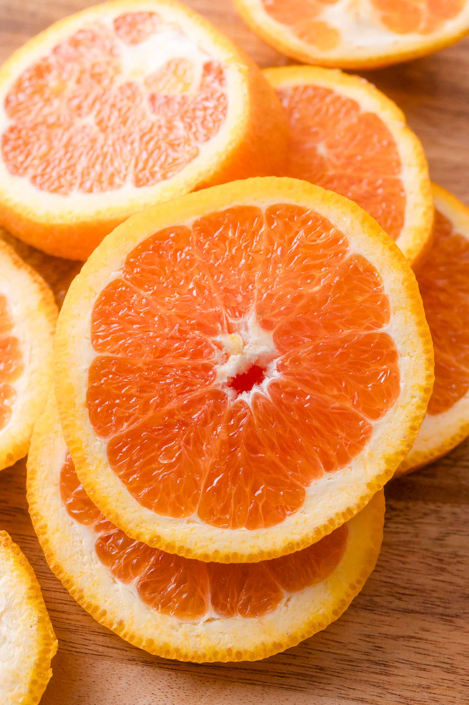 Several slices of oranges arranged on a wooden surface.